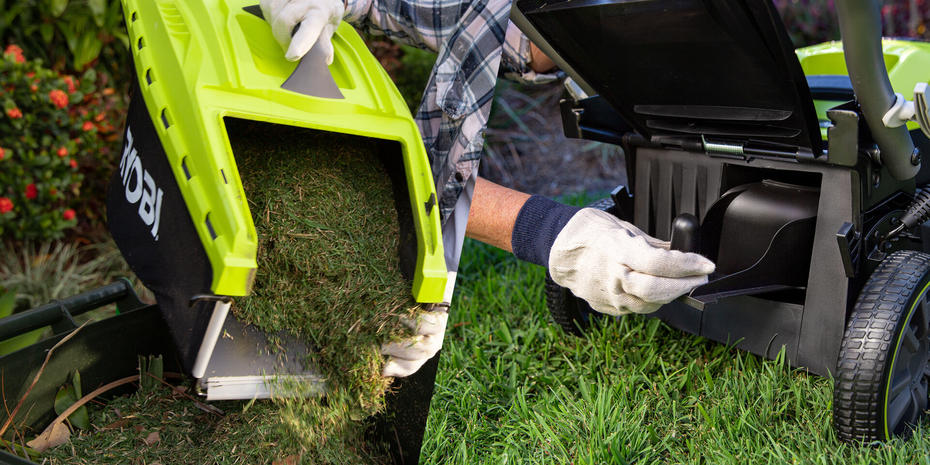 Hand emptying full lawn mower grass catcher