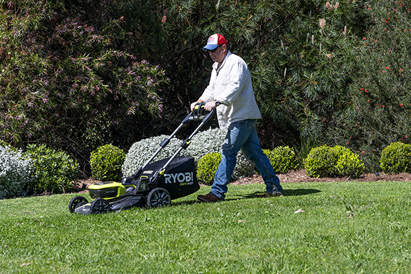 Jason Hodges pushes a RYOBI 36V Lawn Mower