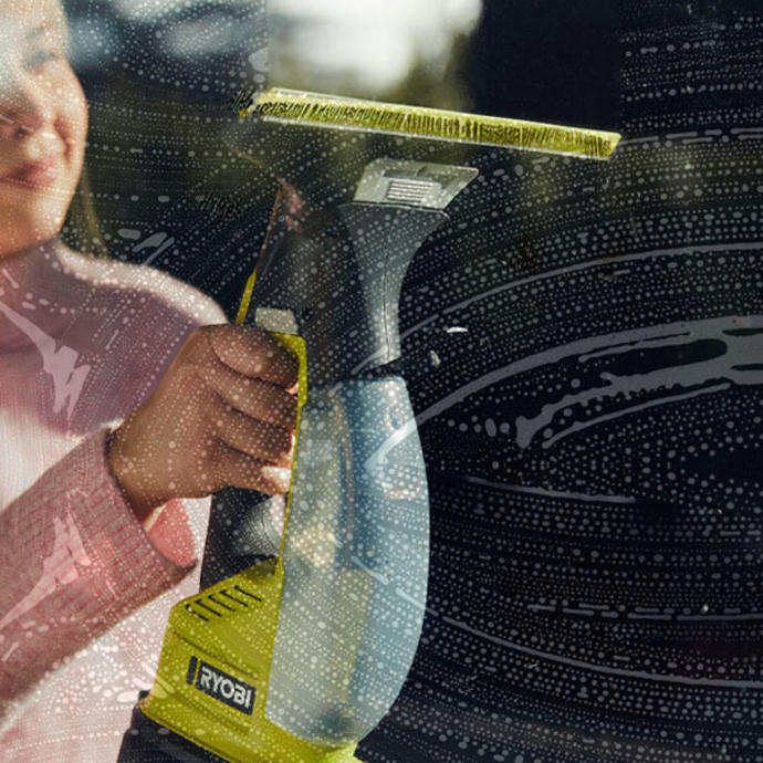A woman uses a Ryobi window vac to clean indoors