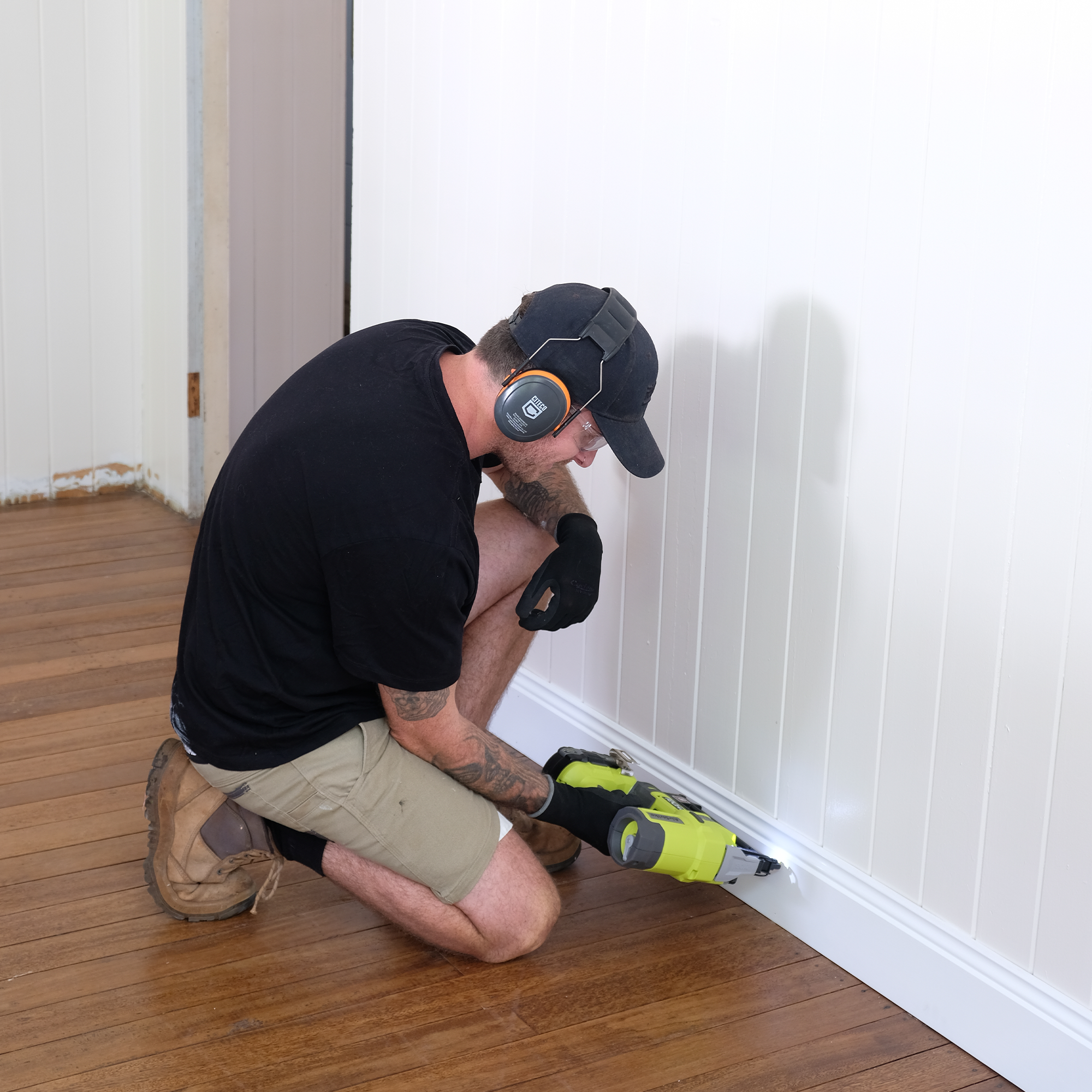 Jake uses a RYOBI brad nailer to fix skirting boards into place. 