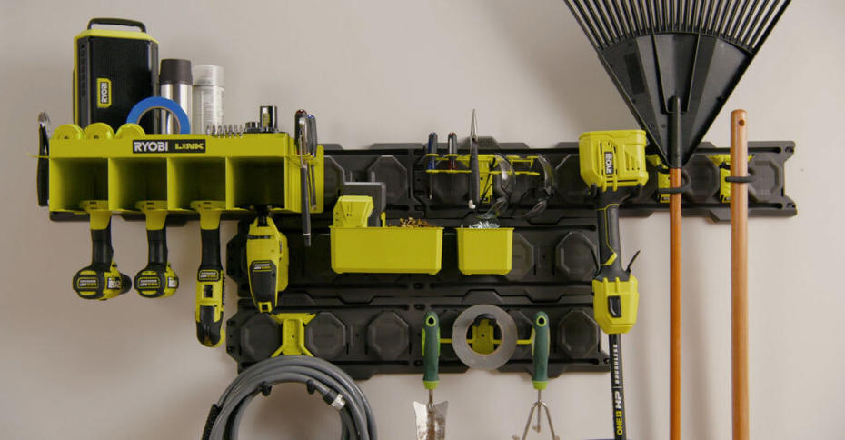 Front image of RYOBI LINK wall with products including a rake and tools hung in orderly manner. 