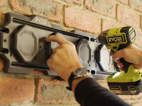 Securing LINK storage system in place with RYOBI drill on a brick wall.