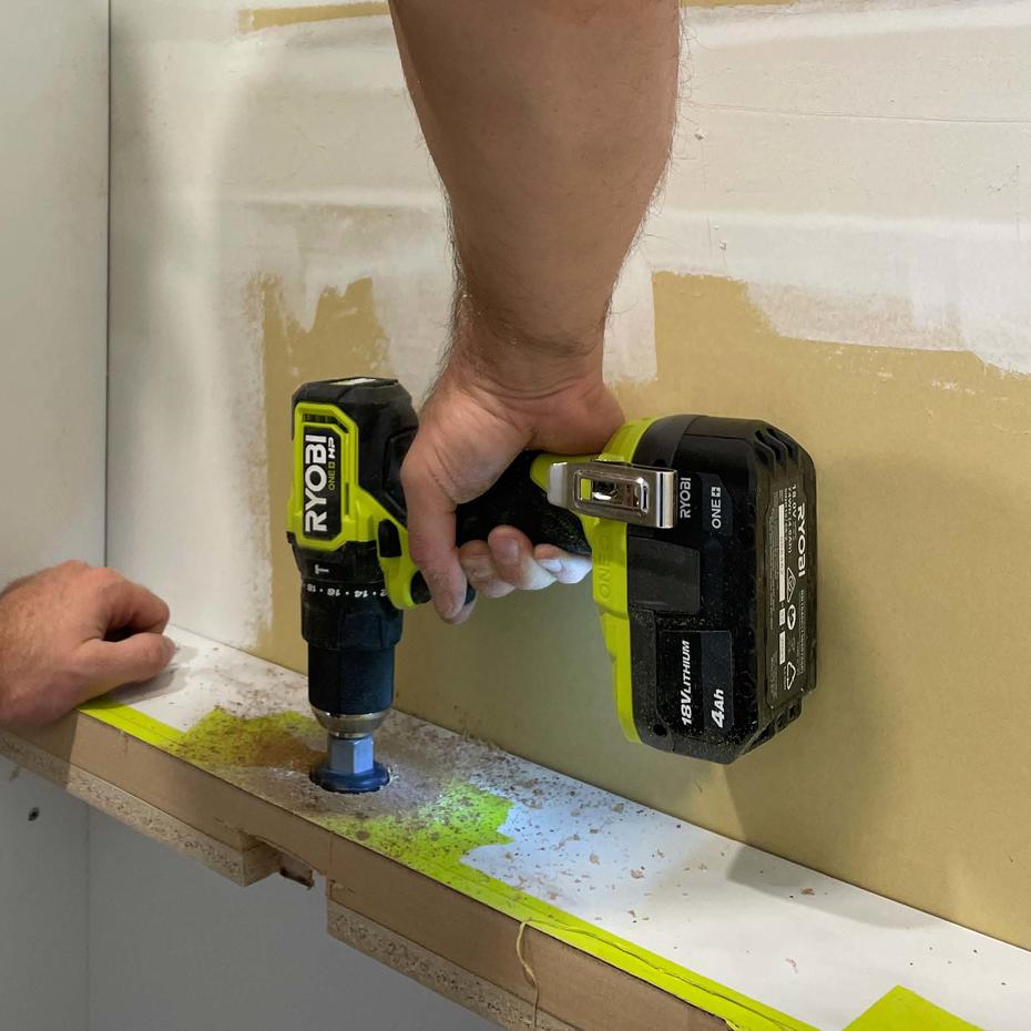 Using a RYOBI drill to make a pilot hole on the top of a cabinet