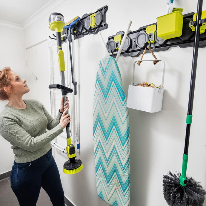 Woman placing tools on a RYOBI LINK storage wall hanger