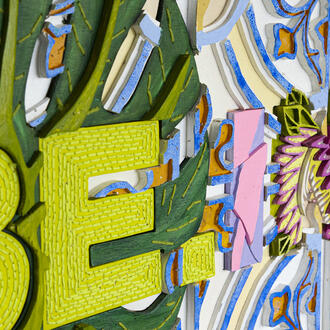 Close up of Be Inspired wooden wall art wording containing bright colours and flower patterns 