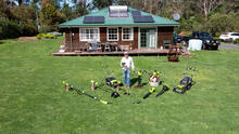 Jason Hodges stands on the lawn surrounded by RYOBI 36V garden equipment