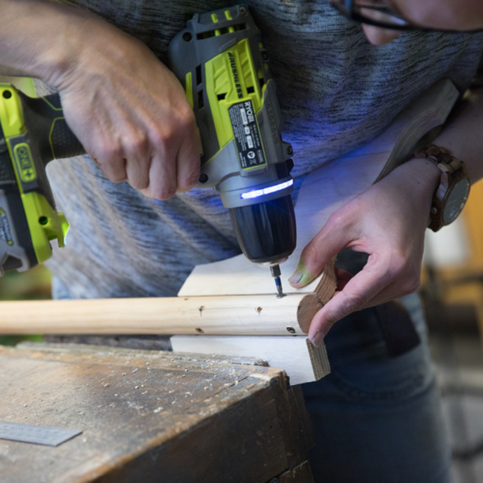 Screwing the legs onto the dowel with a Ryobi drill driver