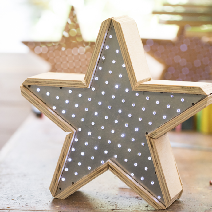 A wooden star decorated with white, LED lights